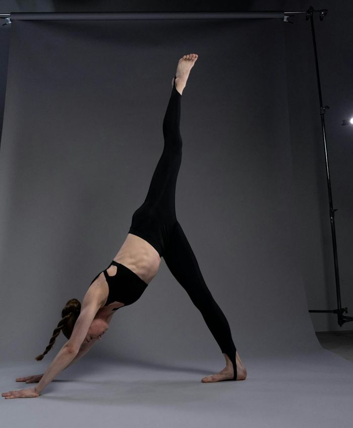 Person practicing yoga balance in a dark atmospheric studio